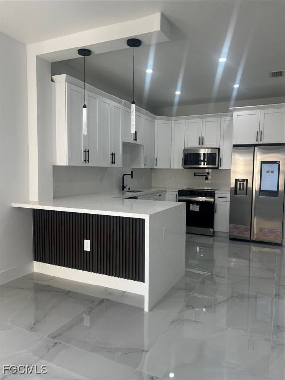 2511 30th Street Southwest Lehigh Acres, FL 33976 - Photo 6 of 15 a kitchen with kitchen island granite countertop a sink a counter top space stainless steel appliances and cabinets