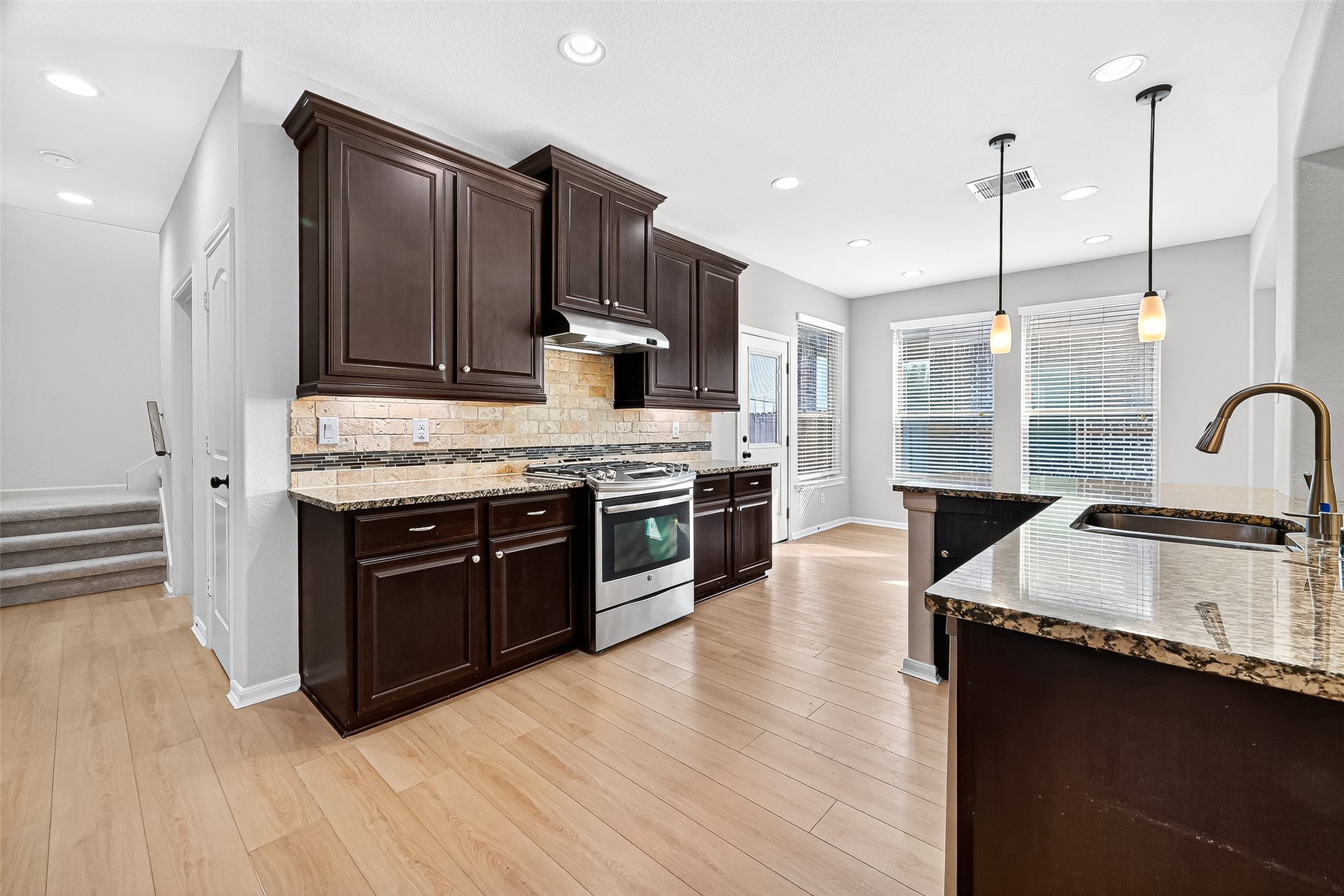1531 Kent Valley Lane Rosenberg, TX 77471 - Photo 16 of 37 a kitchen with stainless steel appliances granite countertop a stove a sink and a wooden floors
