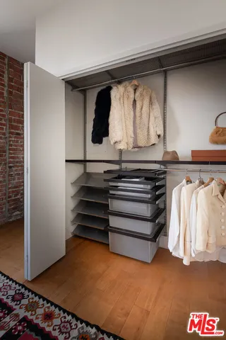 a view of walk in closet with clothes and shoes
