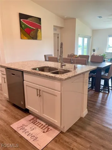 a kitchen with stainless steel appliances granite countertop a stove a sink and a microwave