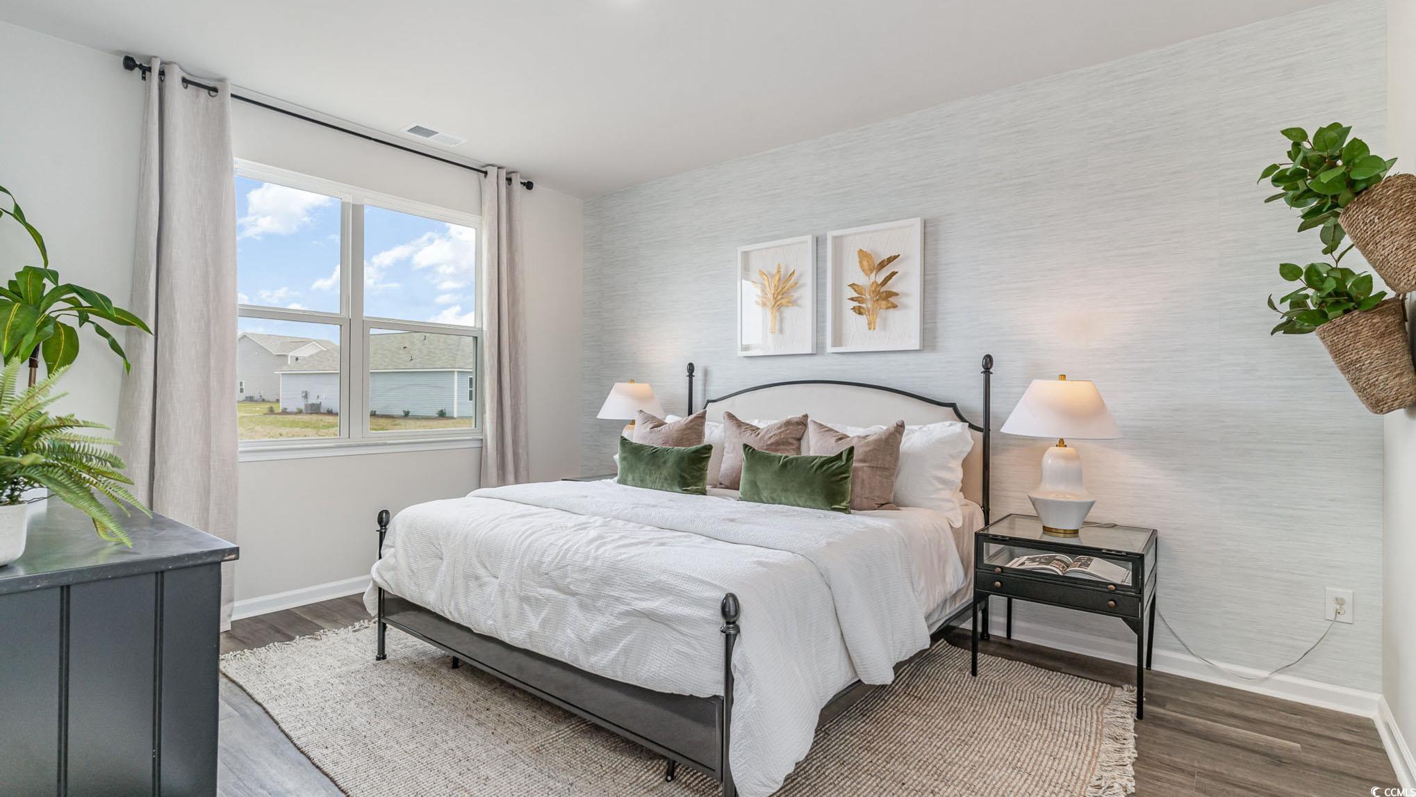 7447 Meadow Walk Loop Loris, SC 29569 - Photo 14 of 23 Bedroom featuring an accent wall, wood finished floors, and wallpapered walls