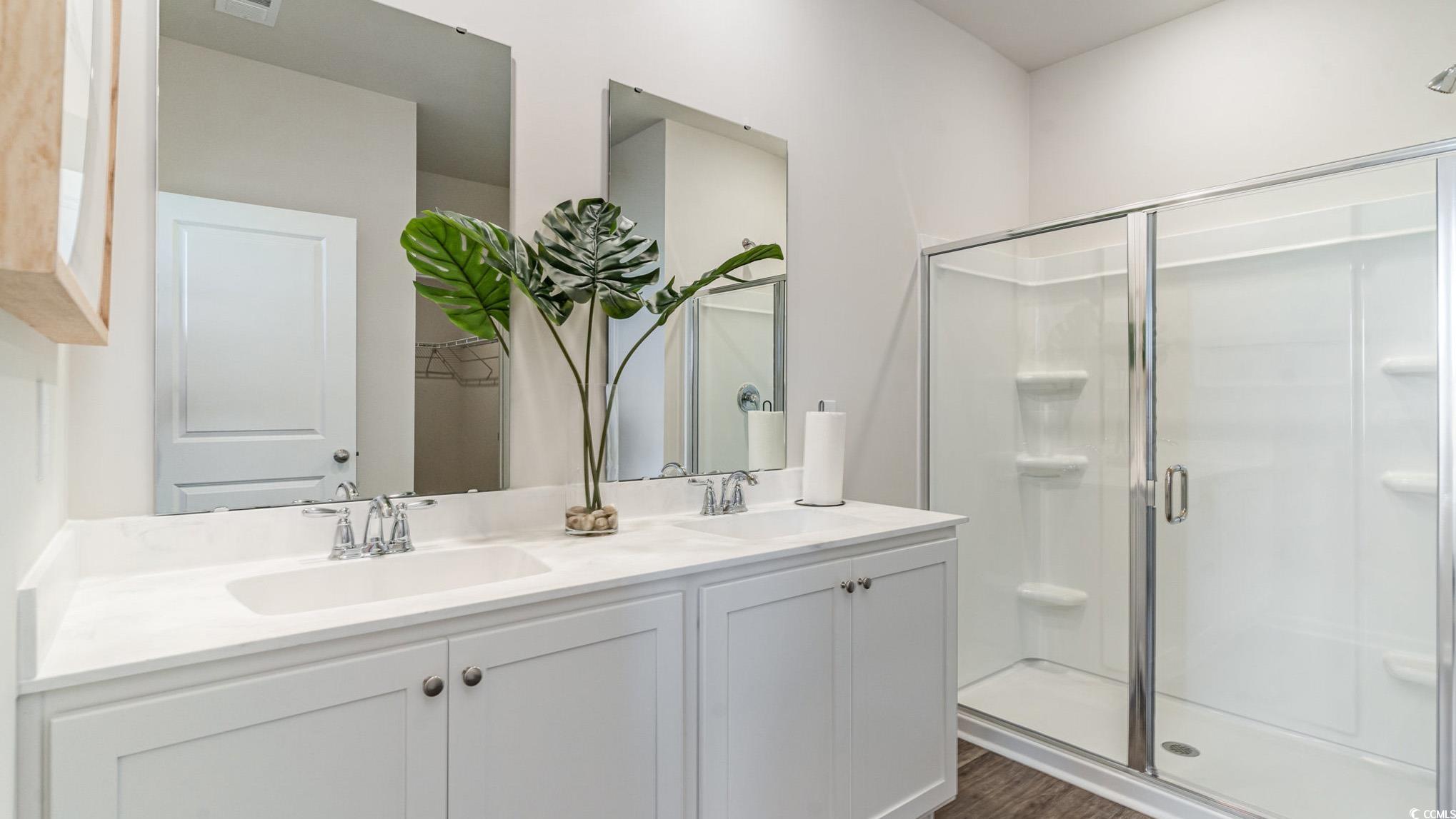 7447 Meadow Walk Loop Loris, SC 29569 - Photo 17 of 23 Full bathroom featuring double vanity, a stall shower, and wood finished floors