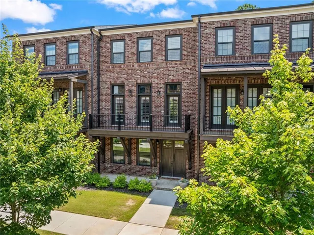 front view of a brick house with a yard