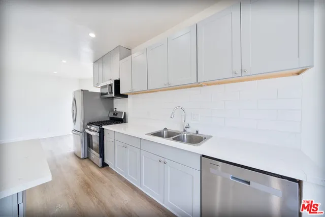 a kitchen with a sink appliances and cabinets