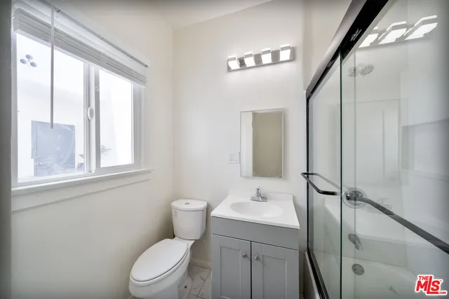 a bathroom with a toilet a sink and a window