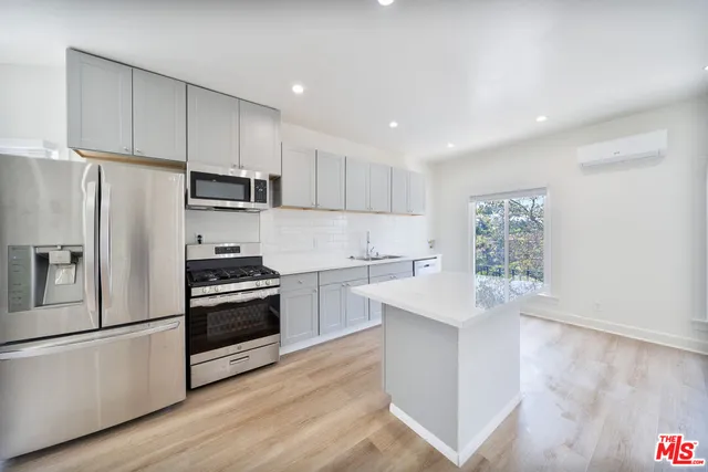 a kitchen with stainless steel appliances granite countertop a refrigerator sink and stove