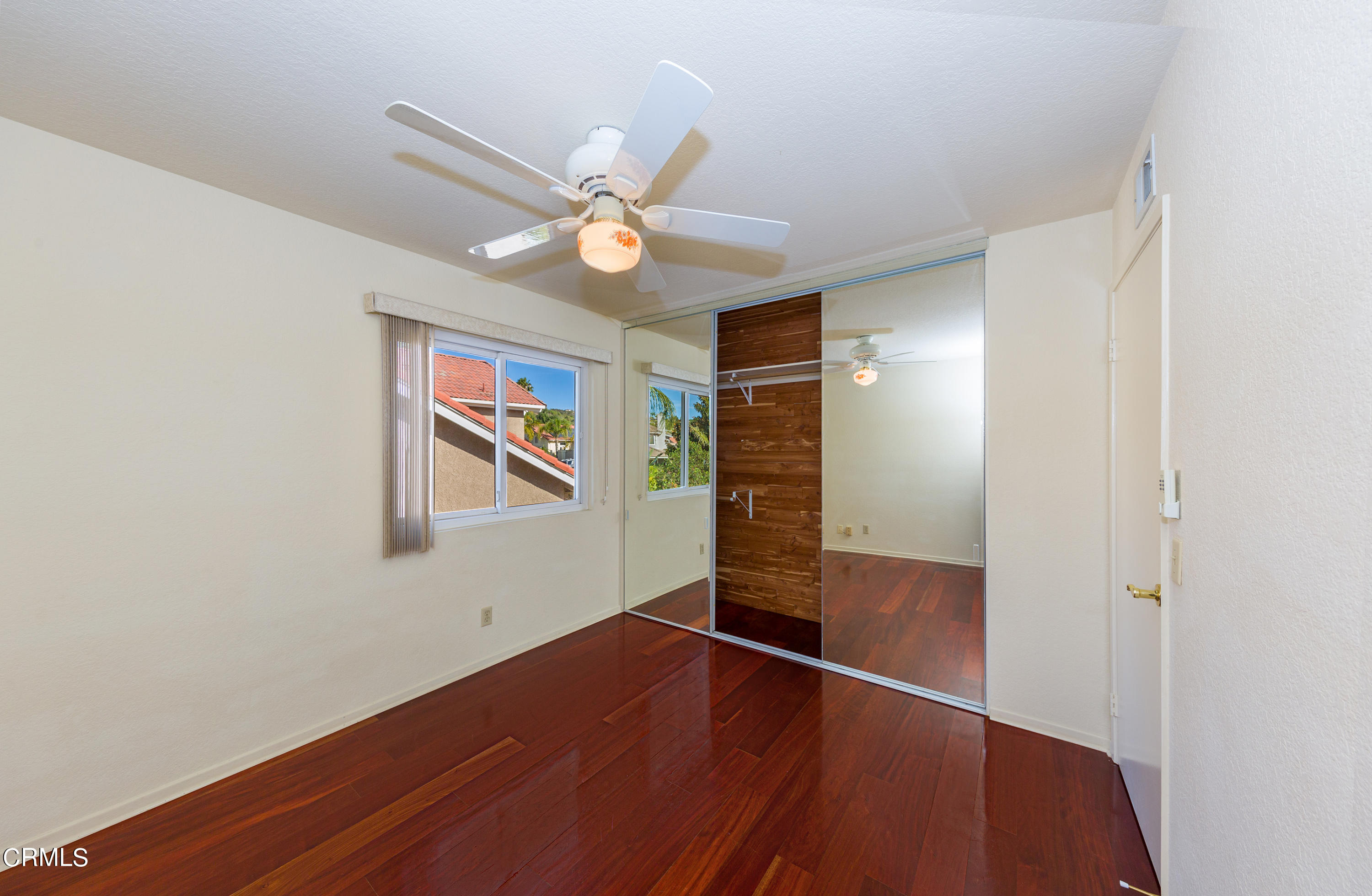 6025 Palomar Circle Camarillo, CA 93012 - Photo 24 of 35 an empty room with wooden floor fan and windows