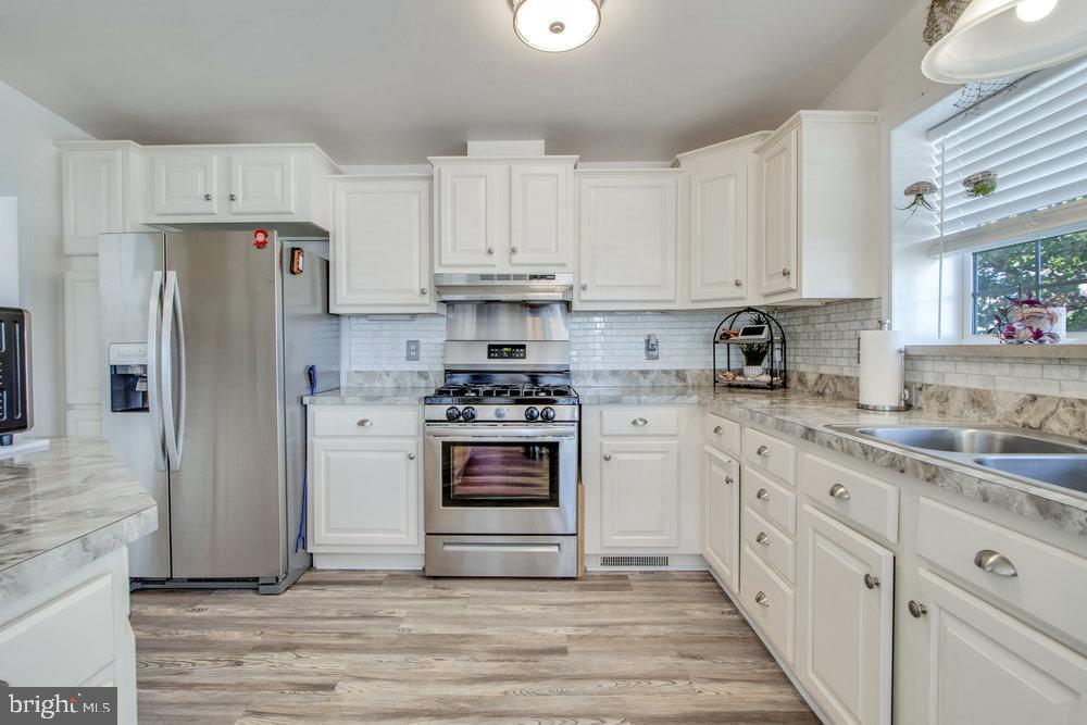 1125 Lorenzo Lane, Unit 274 Smyrna, DE 19977 - Photo 13 of 43 a kitchen with white cabinets and stainless steel appliances