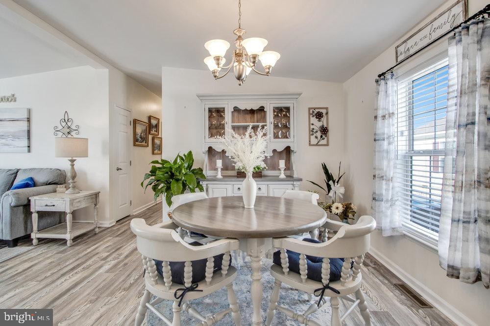 1125 Lorenzo Lane, Unit 274 Smyrna, DE 19977 - Photo 16 of 43 a view of a dining room with furniture and wooden floor