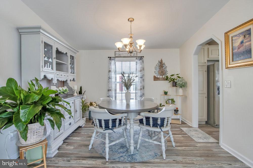 1125 Lorenzo Lane, Unit 274 Smyrna, DE 19977 - Photo 18 of 43 a view of a dining room with furniture wooden floor and a chandelier
