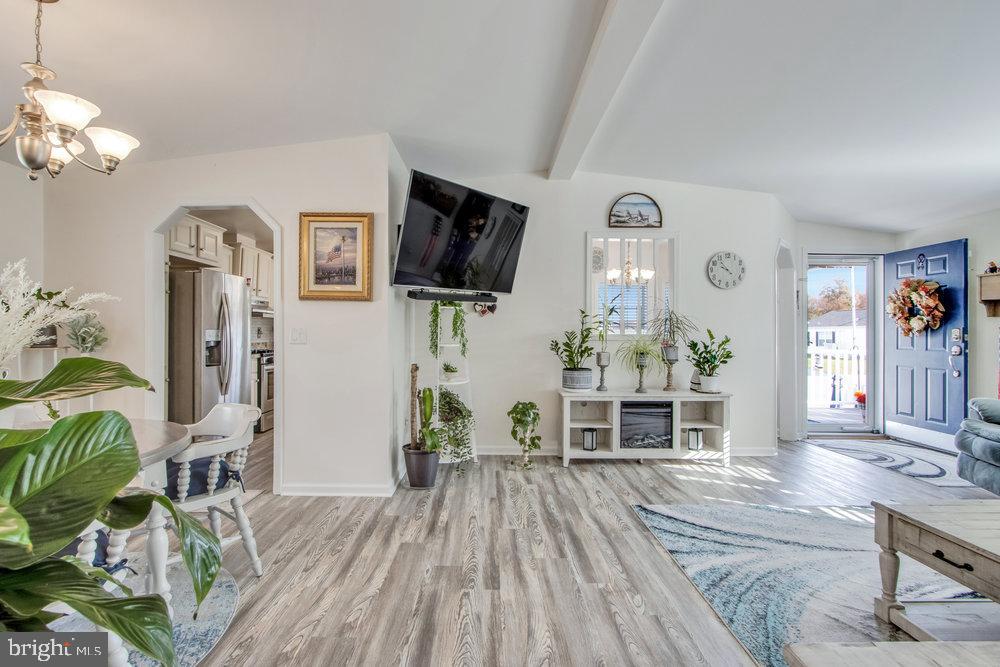 1125 Lorenzo Lane, Unit 274 Smyrna, DE 19977 - Photo 24 of 43 a living room with furniture a chandelier and a flat screen tv
