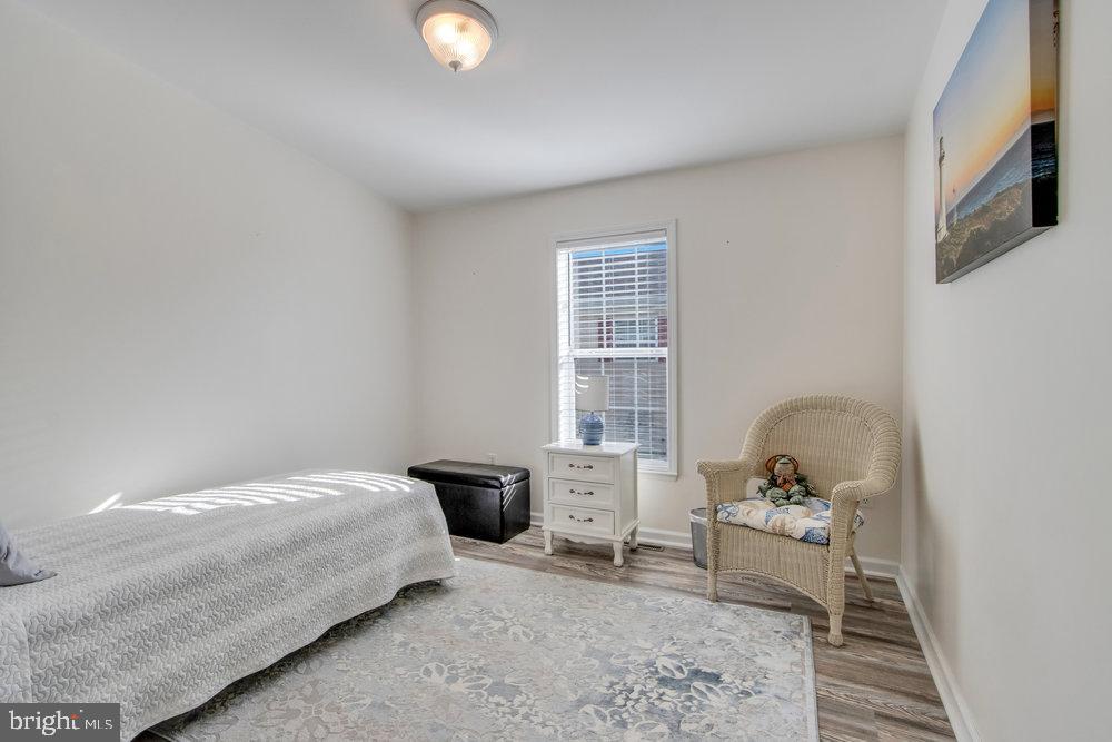 1125 Lorenzo Lane, Unit 274 Smyrna, DE 19977 - Photo 27 of 43 a bedroom with a bed and wooden floor