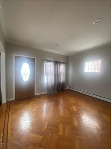 a view of wooden floor and windows in an empty room