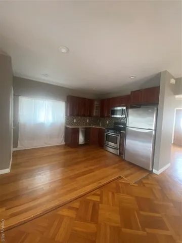 a kitchen with granite countertop a refrigerator and a stove top oven
