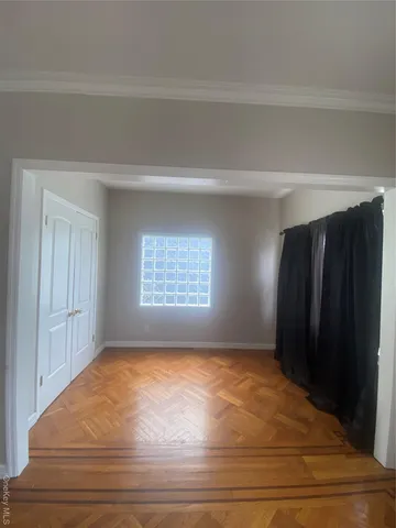 a view of an empty room with closet and a window
