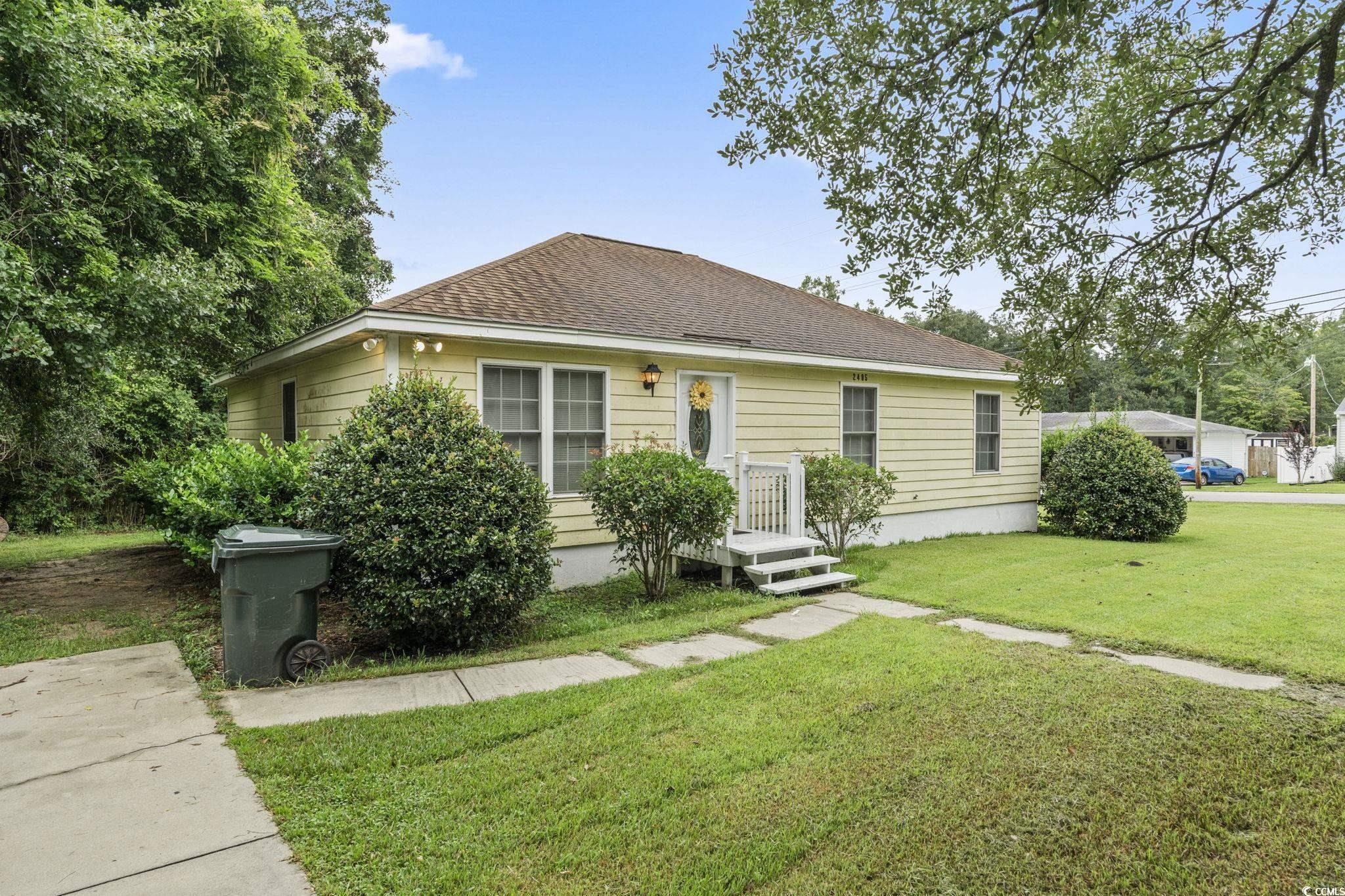 View of front of home with a front lawn and roof with shingles