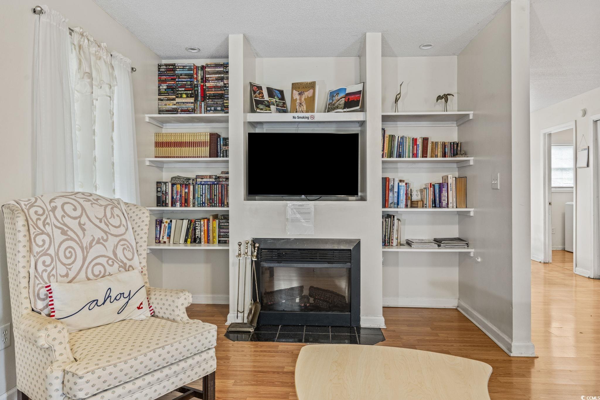 2405 Sherry Avenue Conway, SC 29527 - Photo 6 of 29 Living area with wood finished floors, a fireplace with flush hearth, and a textured ceiling