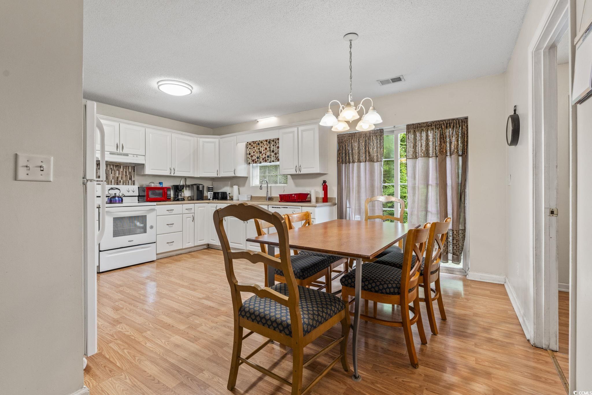 2405 Sherry Avenue Conway, SC 29527 - Photo 7 of 29 Dining room with light wood finished floors, a chandelier, and a textured ceiling