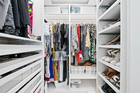 a view of walk in closet with clothes and shoes