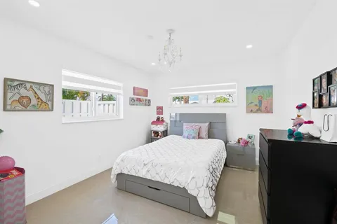 a bedroom with a bed dresser and window