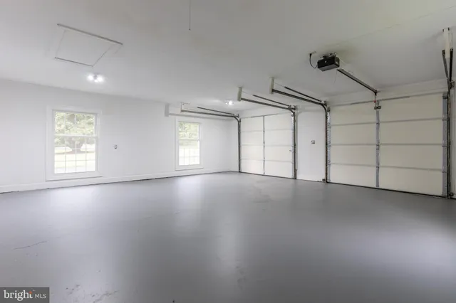 an empty room with windows and ceiling fan