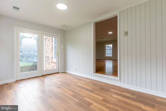 a view of an empty room with glass door and a window