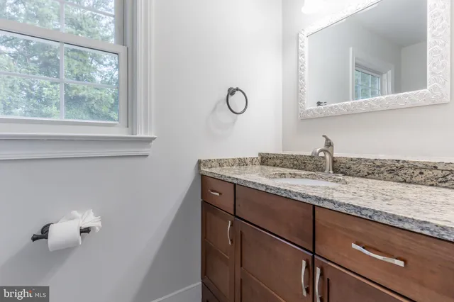 a bathroom with a granite countertop sink and mirror