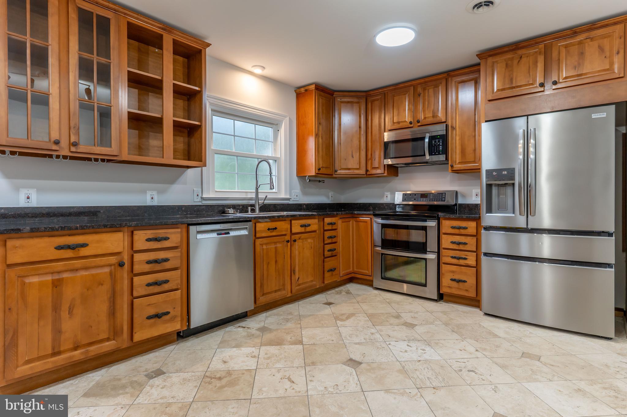 142 Woodland Road Fredericksburg, VA 22401 - Photo 8 of 49 a kitchen with stainless steel appliances granite countertop a refrigerator and wooden cabinets
