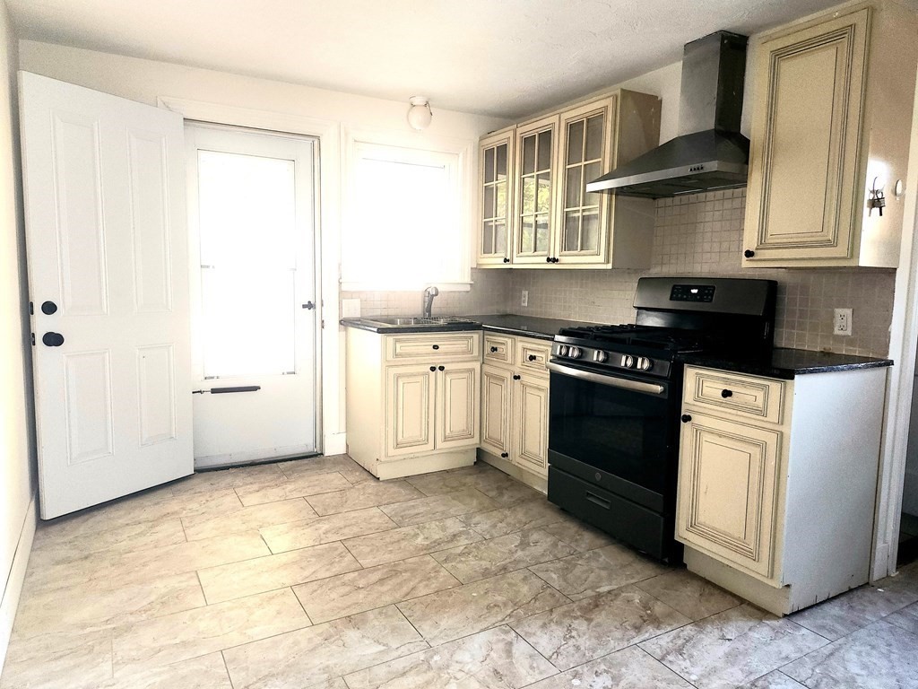 4 Pomona Road Worcester, MA 01602 - Photo 7 of 19 a kitchen with granite countertop a stove a sink and a refrigerator