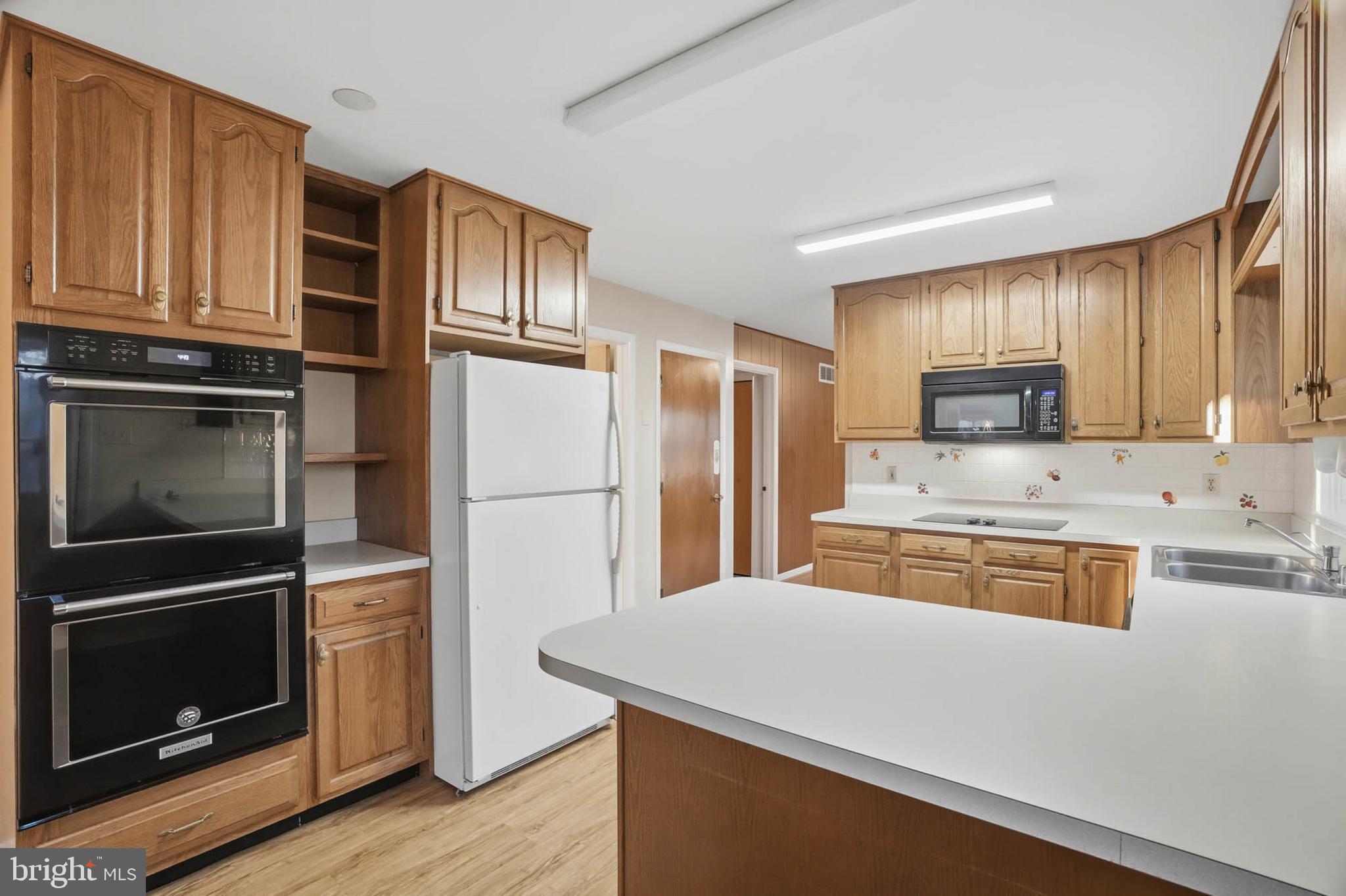 5407 Solomons Island Road Lothian, MD 20711 - Photo 11 of 42 a kitchen with granite countertop stainless steel appliances and wooden cabinets