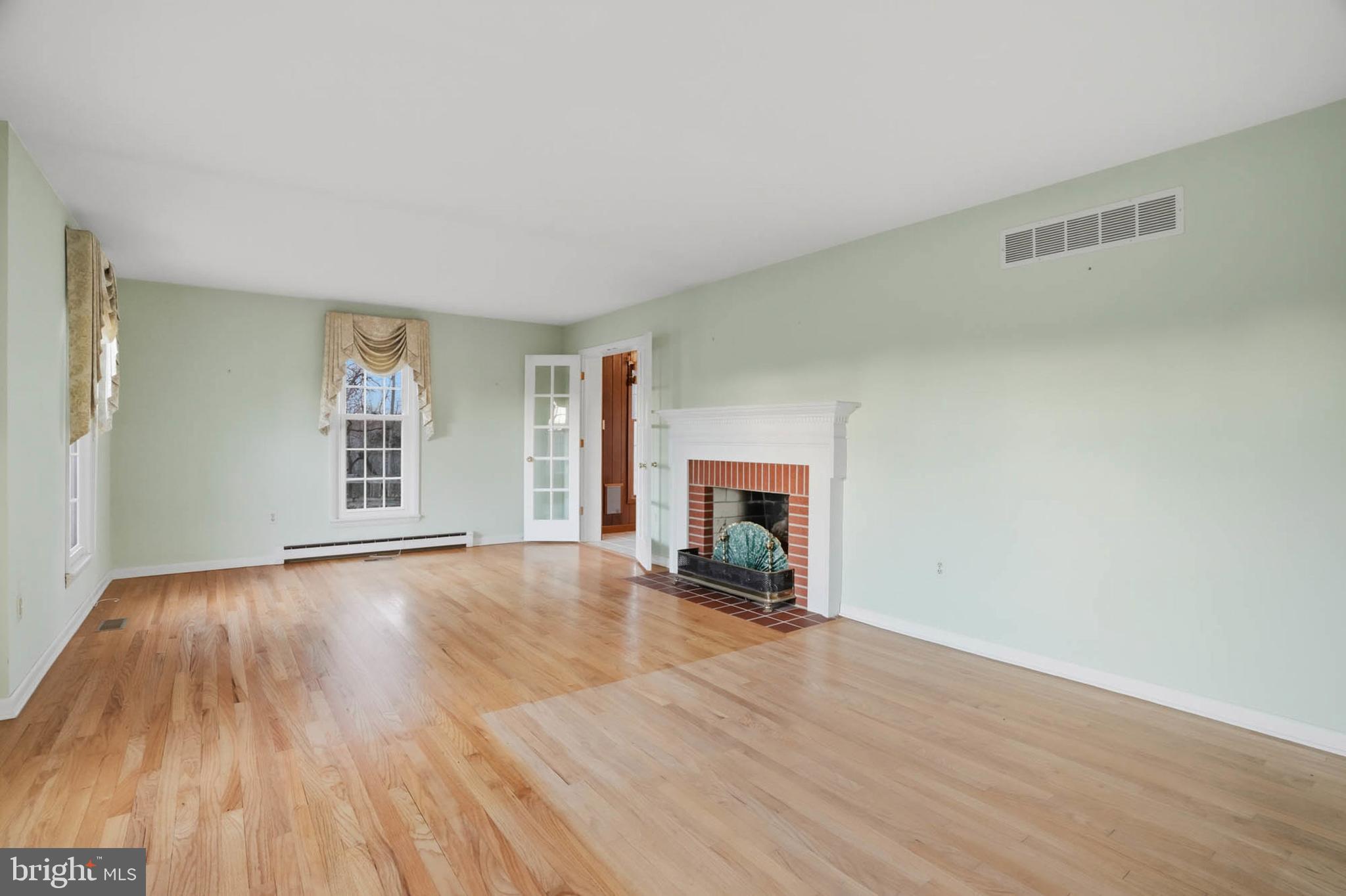 5407 Solomons Island Road Lothian, MD 20711 - Photo 6 of 42 a view of empty room with wooden floor and fireplace