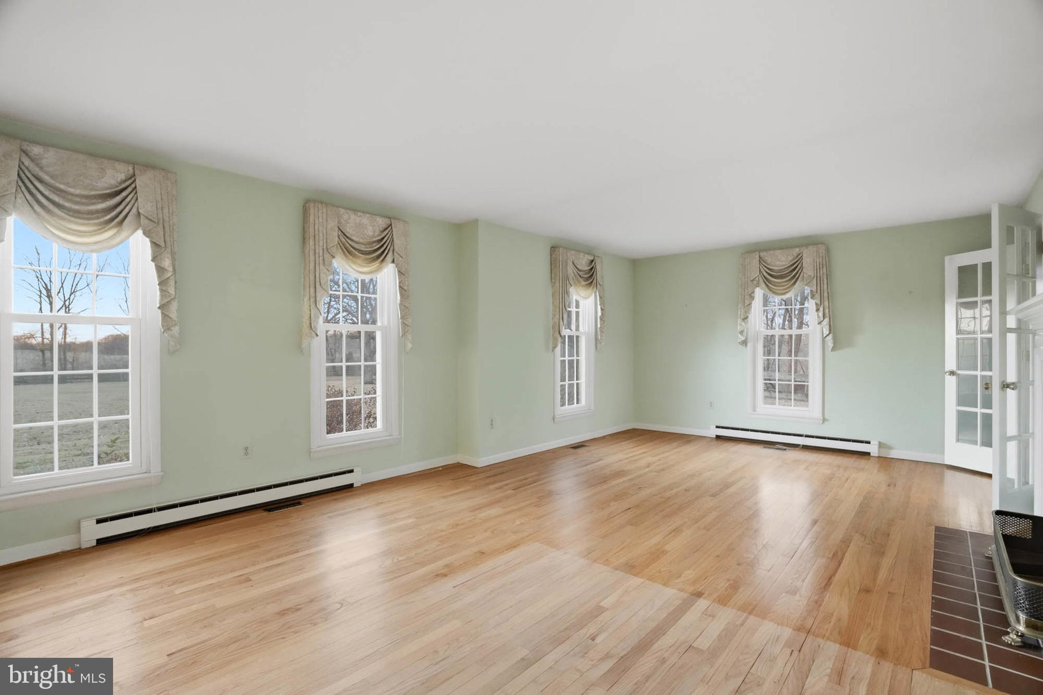 5407 Solomons Island Road Lothian, MD 20711 - Photo 7 of 42 an empty room with wooden floor and windows