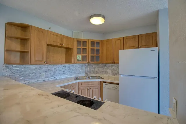 a kitchen with granite countertop a sink and a refrigerator