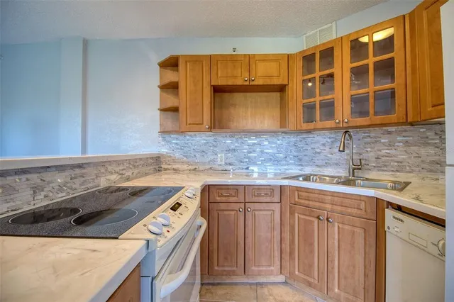 a kitchen with a refrigerator sink and cabinets