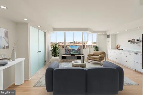 a living room with stainless steel appliances kitchen island granite countertop a couch and a view of living room
