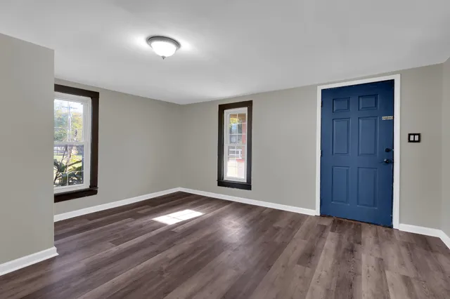 an empty room with windows and closet