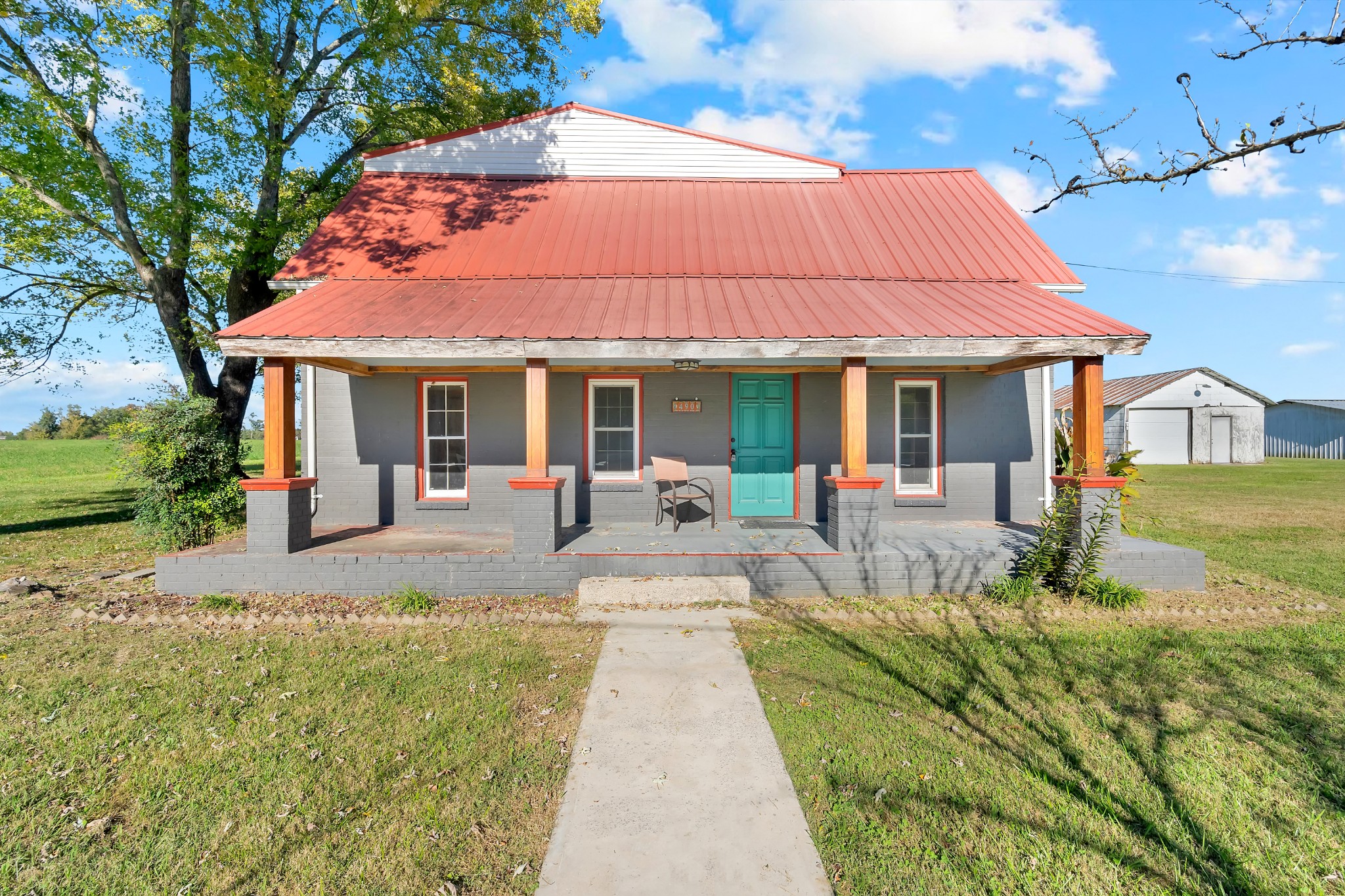 490 Shady Grove Road Manchester, TN 37355 - Photo 2 of 49 a view of a white house with a big yard plants and large tree