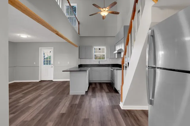 a kitchen with kitchen island wooden floor and refrigerator