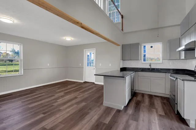 a kitchen with granite countertop a stove a sink and a refrigerator