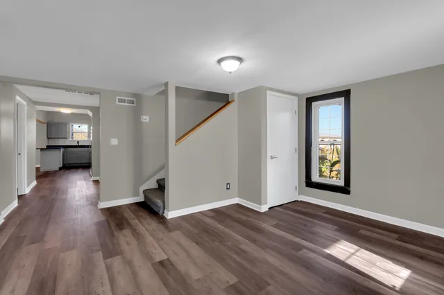 a view of a big room with wooden floor and windows