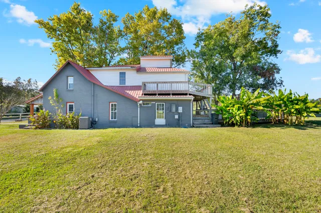 a front view of house with yard and trees in the background