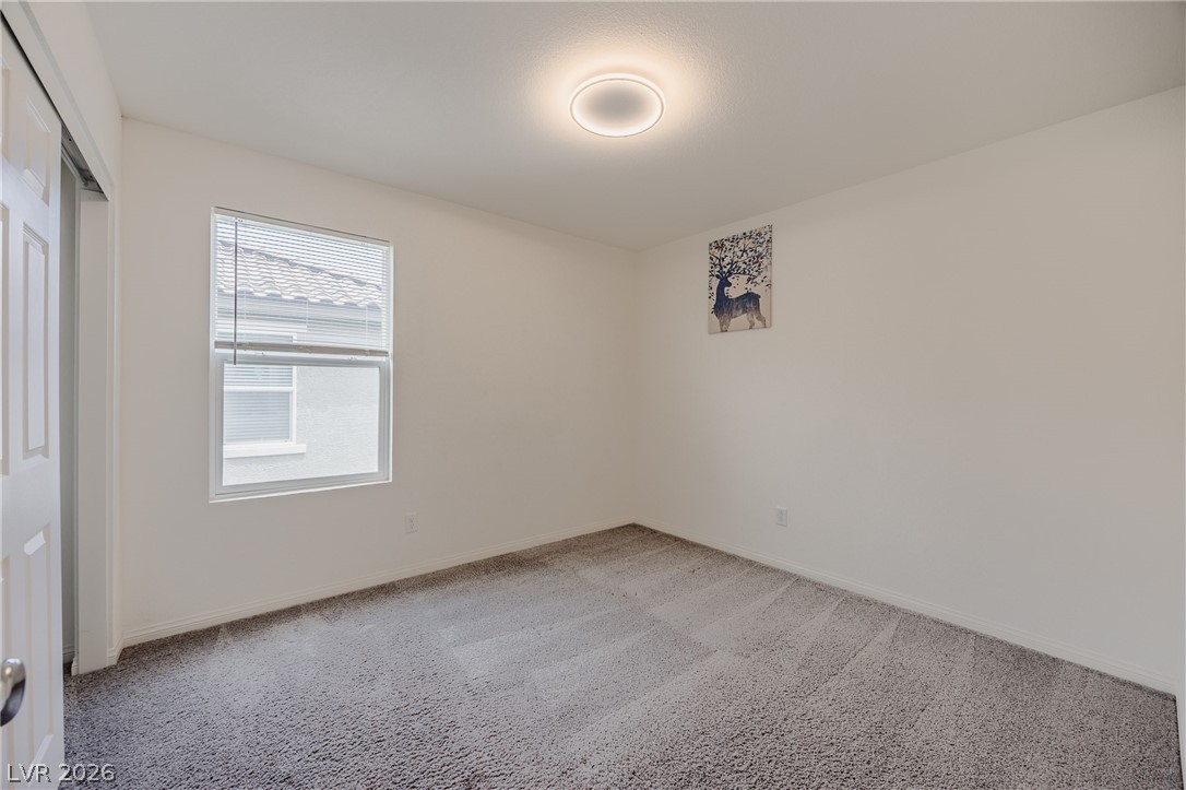 5927 Coja Street Las Vegas, NV 89113 - Photo 25 of 32 Unfurnished bedroom featuring light colored carpet, baseboards, and a closet