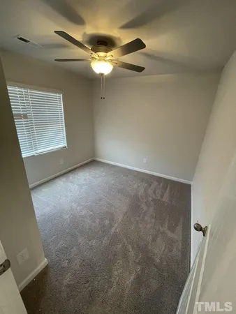 a view of a livingroom with a ceiling fan and window