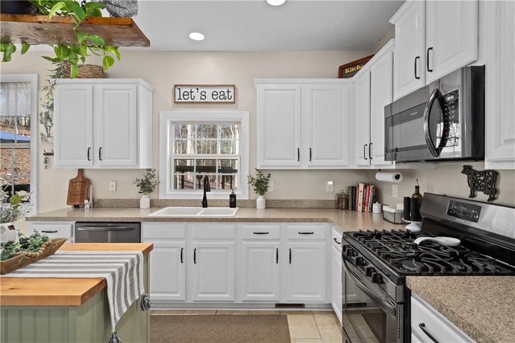 129 Boulder View Court Dallas, GA 30157 - Photo 12 of 43 a kitchen with stainless steel appliances granite countertop a stove a sink dishwasher and cabinets with wooden floor