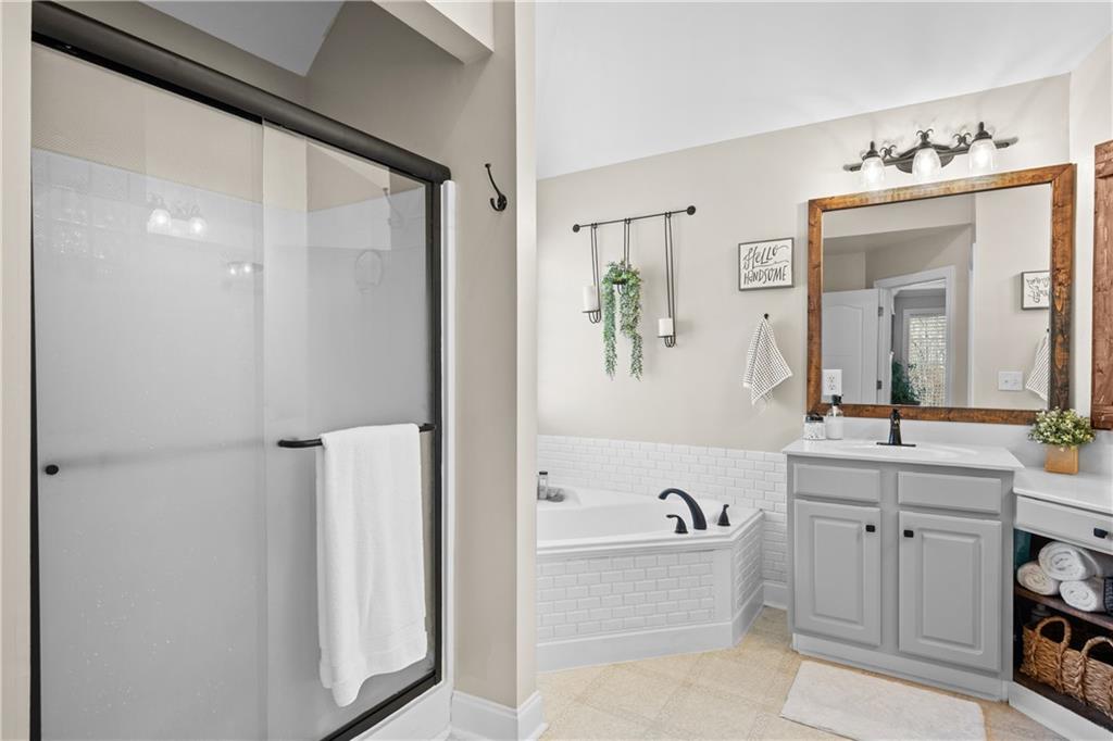 129 Boulder View Court Dallas, GA 30157 - Photo 22 of 43 a spacious bathroom with a bathtub sink and mirror