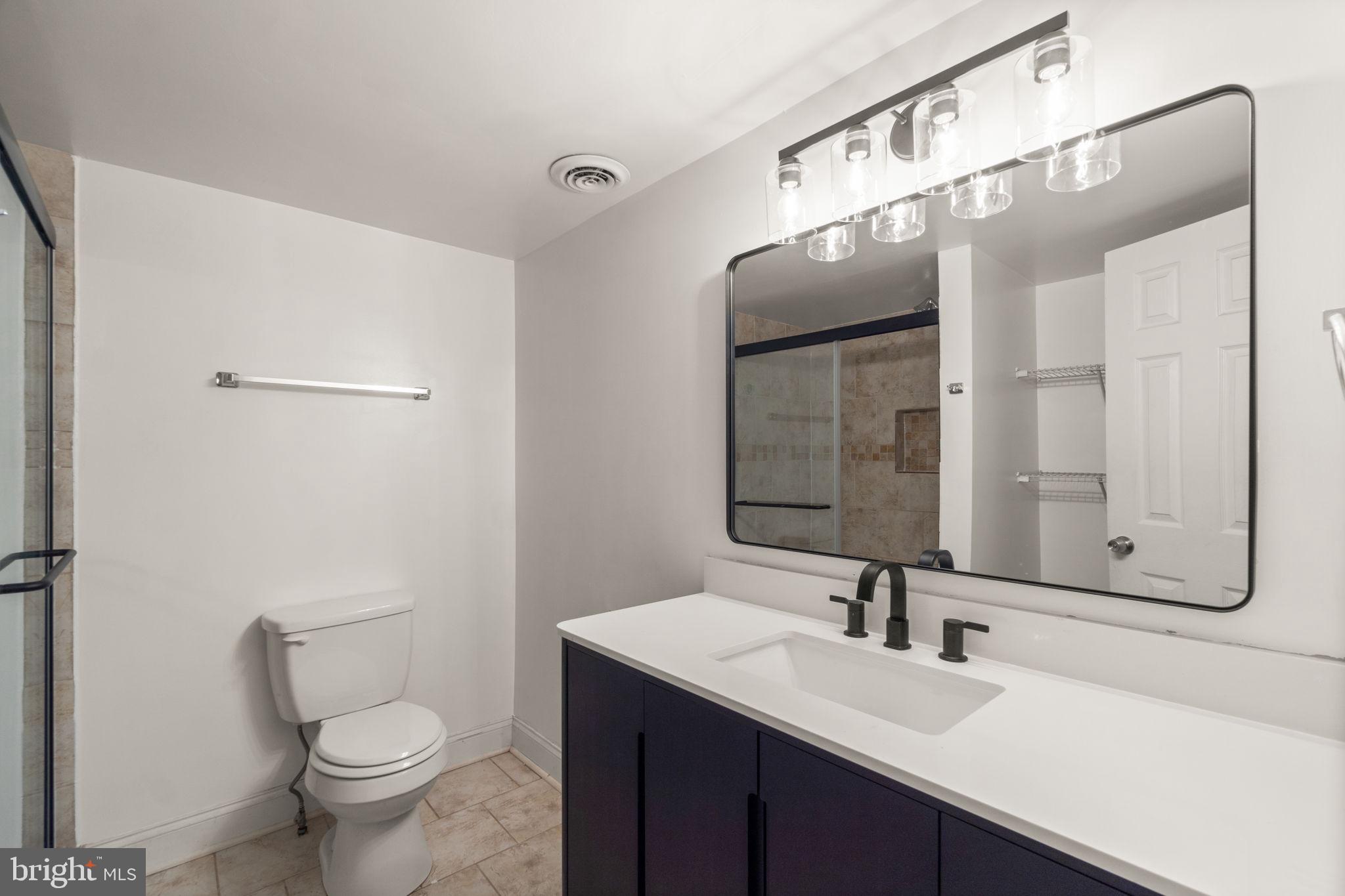 9528 Wandering Way Columbia, MD 21045 - Photo 19 of 29 a bathroom with a toilet a sink a mirror and vanity