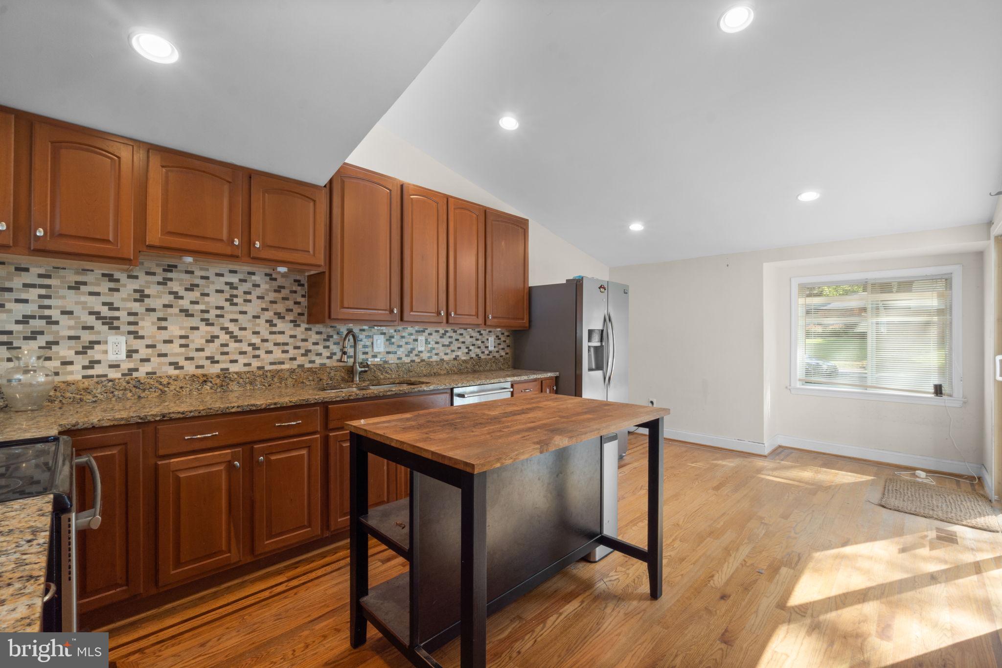 9528 Wandering Way Columbia, MD 21045 - Photo 9 of 29 a kitchen with stainless steel appliances granite countertop wooden cabinets a stove top oven a sink and dishwasher