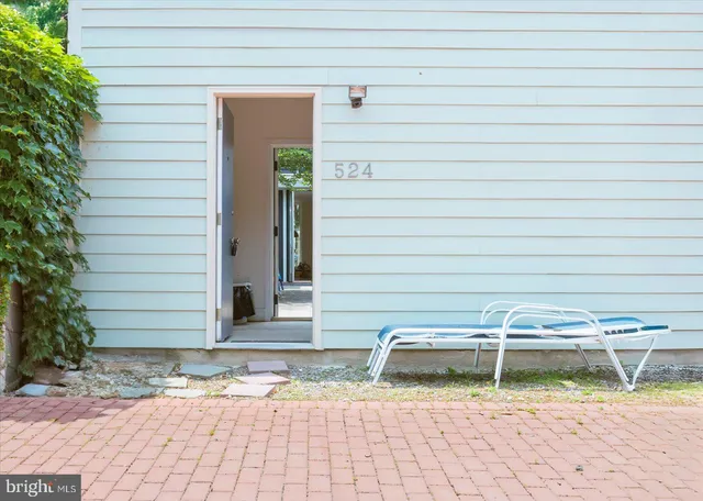 a front view of a house with a yard and potted plants