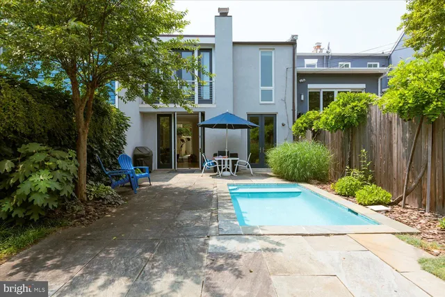 a view of a house with potted plants and a fountain