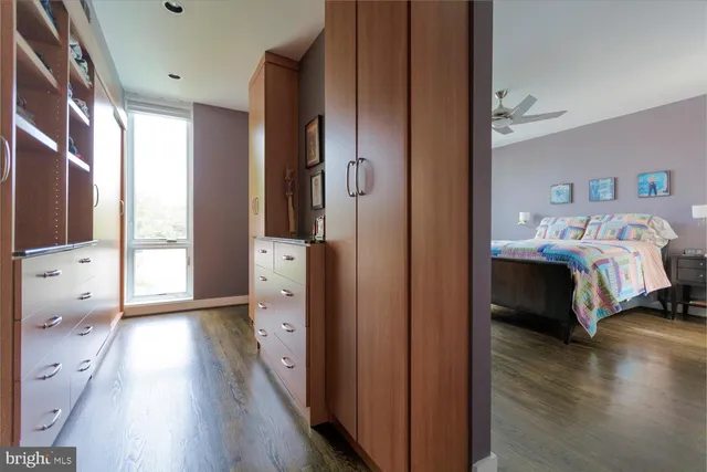 a en suite spacious bedroom with a bed and a flat tv screen on dresser